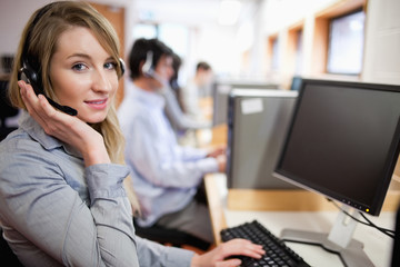 Smiling blonde operator posing with a headset