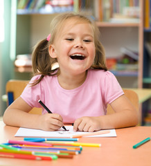 Little girl is drawing with felt-tip pen