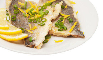 Two pieces of fried fish and lemon segment