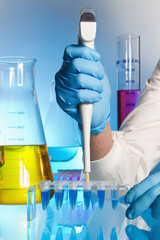 Cientifico depositando una muestra de liquido azul en unos tubos