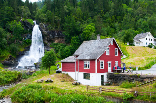 Red wooden house and waterfall Steindalsfossen. Norway