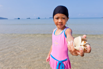 Little cute girl Shell in hand at the beach