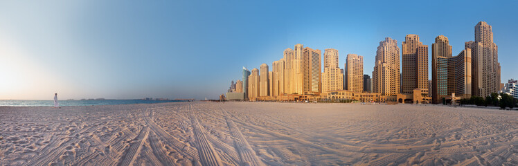 Naklejka premium Kobieta patrzy na Dubai City (Marina) na plaży Jumeirah