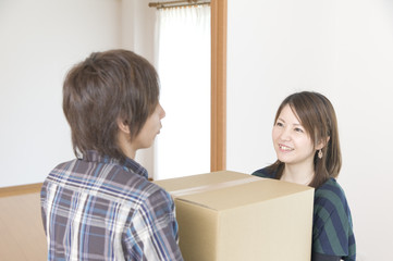 引っ越しの荷物を運ぶカップル