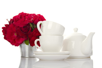 White crockery for tea and a bouquet of roses