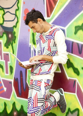 Obraz na płótnie Canvas Style boy with laptop near graffiti wall.