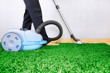 Vacuum cleaner in action  - a men cleaner a carpet.