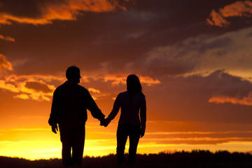 Couple walks at sunset.