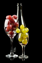 grapes in a glass and a bottle of wine