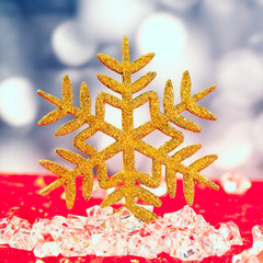 Christmas golden snowflake on ice cubes