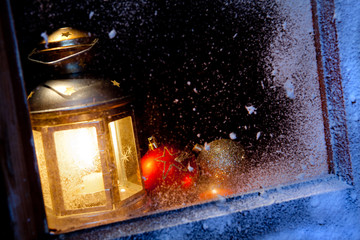 finestra con neve e lanterna