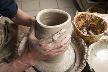 hands of a potter, creating an earthen jar on the circle