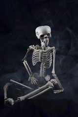 Fototapeta na wymiar Skeleton holding an ashtray