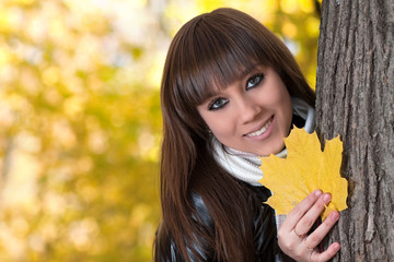 Girl with a maple leaf in palms