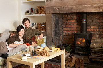 Young couple relaxing by fire