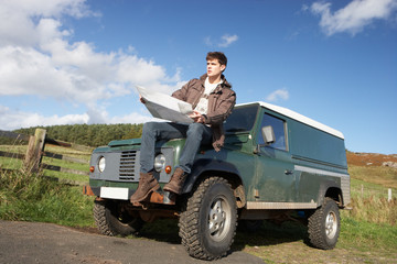 Fototapeta premium Young man in countryside with SUV