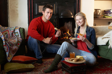 Young couple making toast on open fire