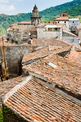 view on ancient tile roofs and church tower in sicilian town