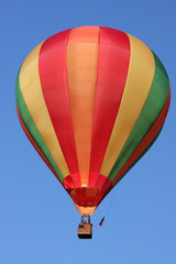 montgolfière rayée dans un grand ciel bleu