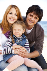 Obraz premium Young family at the beach in fall.