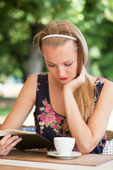 beautiful girl has a rest in street cafe in park