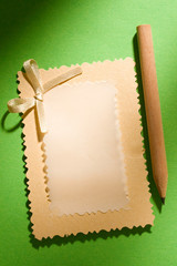 Greeting card and pencil isolated on the green background