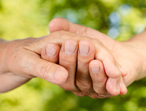 Closeup of senior hands holding together