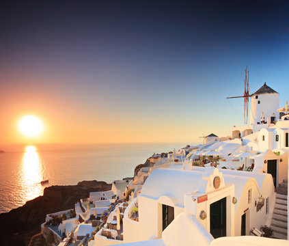 Fototapeta A view of a village on Santorini island and a sunset