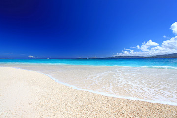 Fototapeta na wymiar Głębokie błękitne niebo i jasny kipiel w czystej piaszczystej plaży