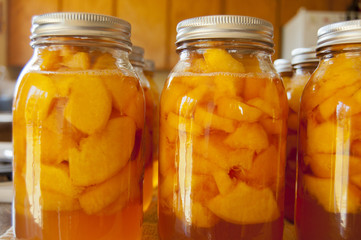 Glass jars of home canned peaches - obrazy, fototapety, plakaty