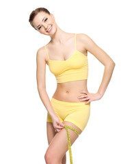 Fototapeta premium woman measuring hip by tape after fitness