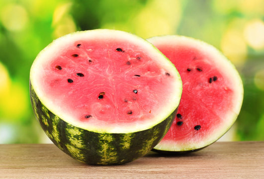 Ripe sweet watermelon on wooden table on green  background