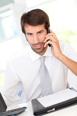 Businessman using cellphone in office