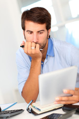 Portrait of office worker using electronic tablet