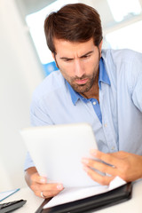 Portrait of office worker using electronic tablet