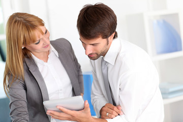 Business people in office using electronic tablet