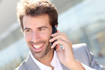 Portrait of cheerful businessman talking on mobile phone