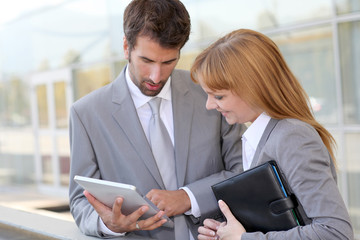 Obraz premium Business people working outside on electronic tablet