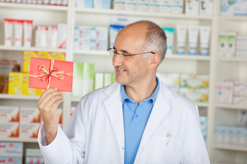 lächelnder apotheker mit gutschein