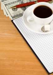 cup of coffee and notebook with dollar