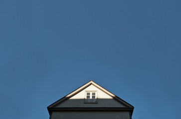 Giebel eines Hauses vor blauem Himmel