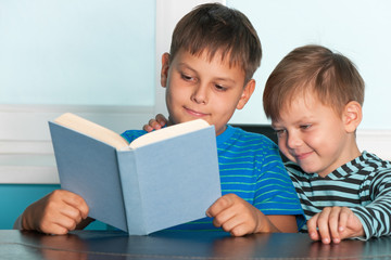 Fototapeta na wymiar Dwa czytania chłopcy na biurku