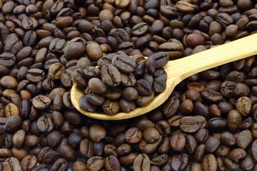 Coffee beans with wooden spoon close-up