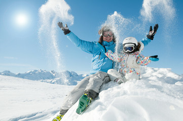 Winter fun - happy skiers playing in snow