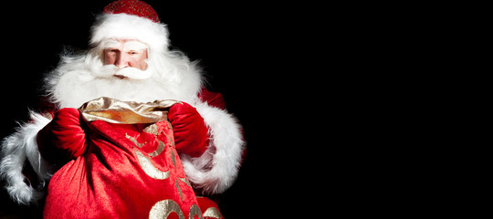 Santa sitting at the Christmas room and looking into the sack
