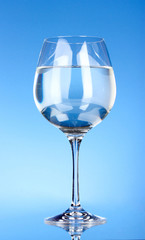 Glass of water on blue background