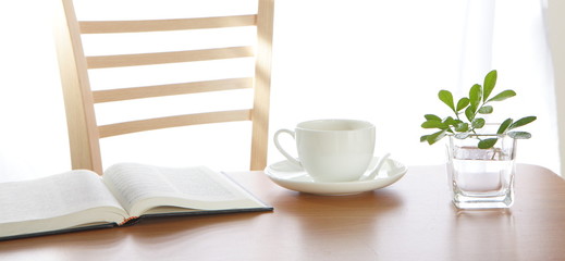 Cup book and plant on wooden table