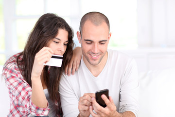 Young couple doing online shopping with smartphone