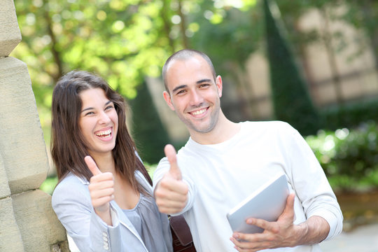 Young couple in public park with electronic tablet