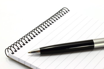 Notepad with ball pen on a white background